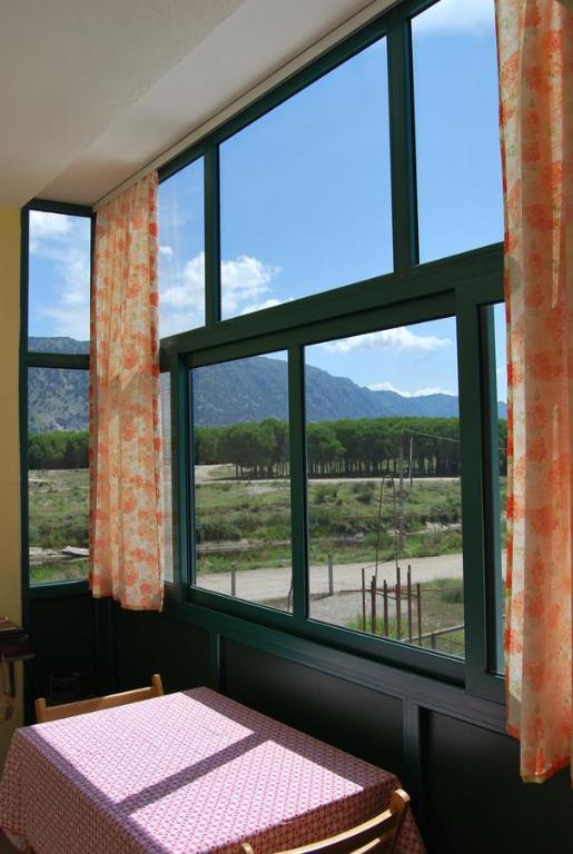 Habitación con mesa y ventana con vistas. en H and H Guesthouse, en Velipojë