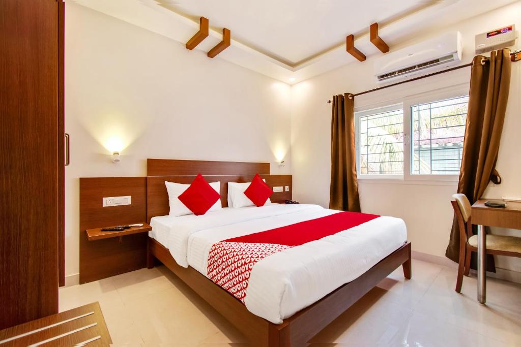a bedroom with a large bed with red pillows at OYO Hotel Resida Elite Service Apartments Near Manipal hospital in Bangalore