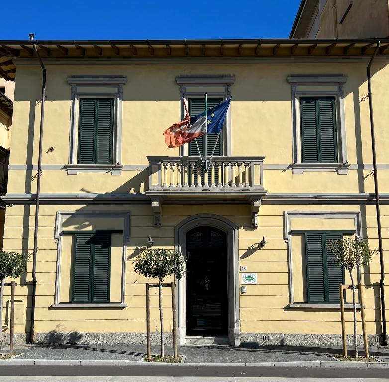 un edificio con balcón y una bandera. en B&B Villa Primavera, en Pisa