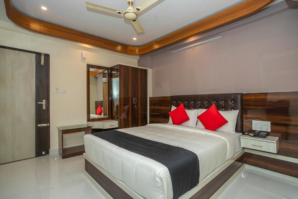 - une chambre avec un grand lit et des oreillers rouges dans l'établissement Super Capital O Boulevard Elite Madiwala Near Ragigudda Sri Prasanna Anjanayeswamy Temple, à Bangalore