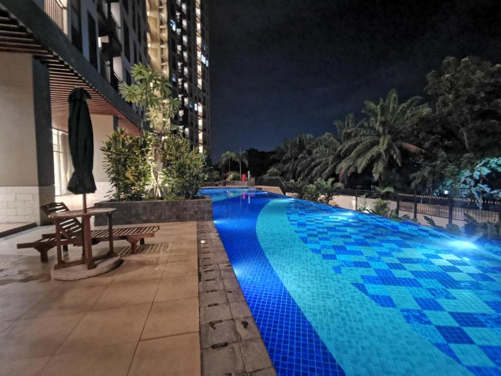 a swimming pool at night in a city at Transpark Cibubur By Arsakha Property Management in Kalimanggis