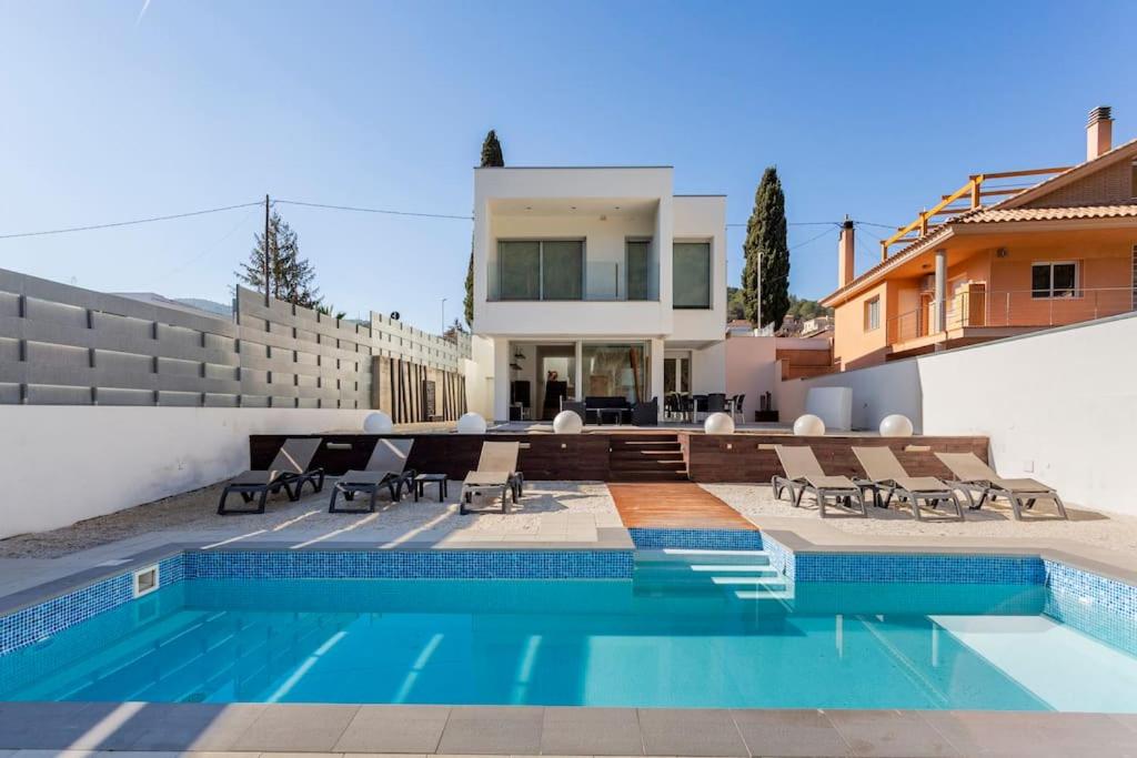 une maison avec une piscine en face d'une maison dans l'établissement Exclusiva Villa de Lujo con piscina, à Canyelles