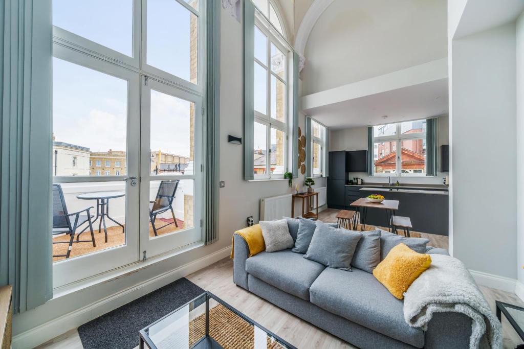 a living room with a couch and large windows at The Old Town Hall - 12 in Staines