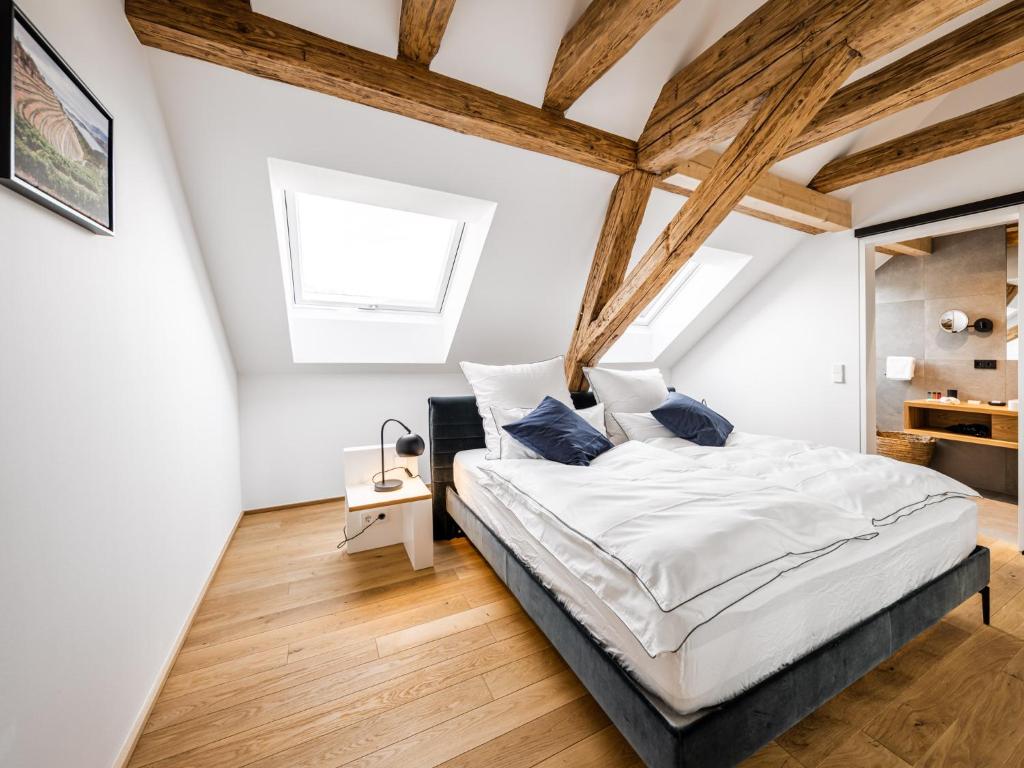 Schlafzimmer mit weißen Wänden und Holzbalken in der Unterkunft Alte Schule Tiefenbach in Tiefenbach