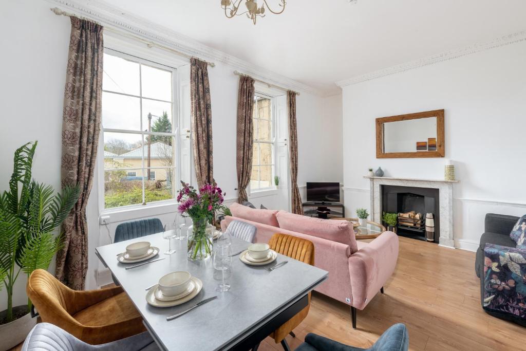 a living room with a table and chairs at Garden maisonette in Bath city centre in Bath
