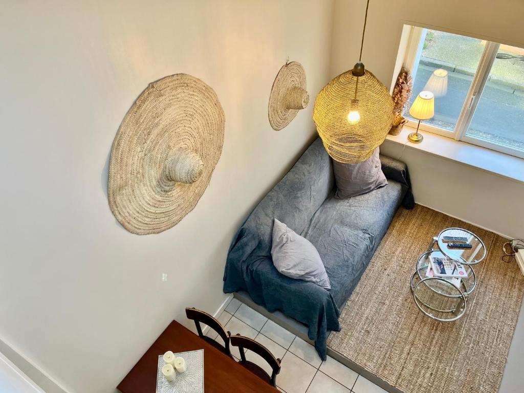 un salon avec un canapé bleu et une fenêtre dans l'établissement L'Atelier du Vieux Port avec Parking, à La Rochelle