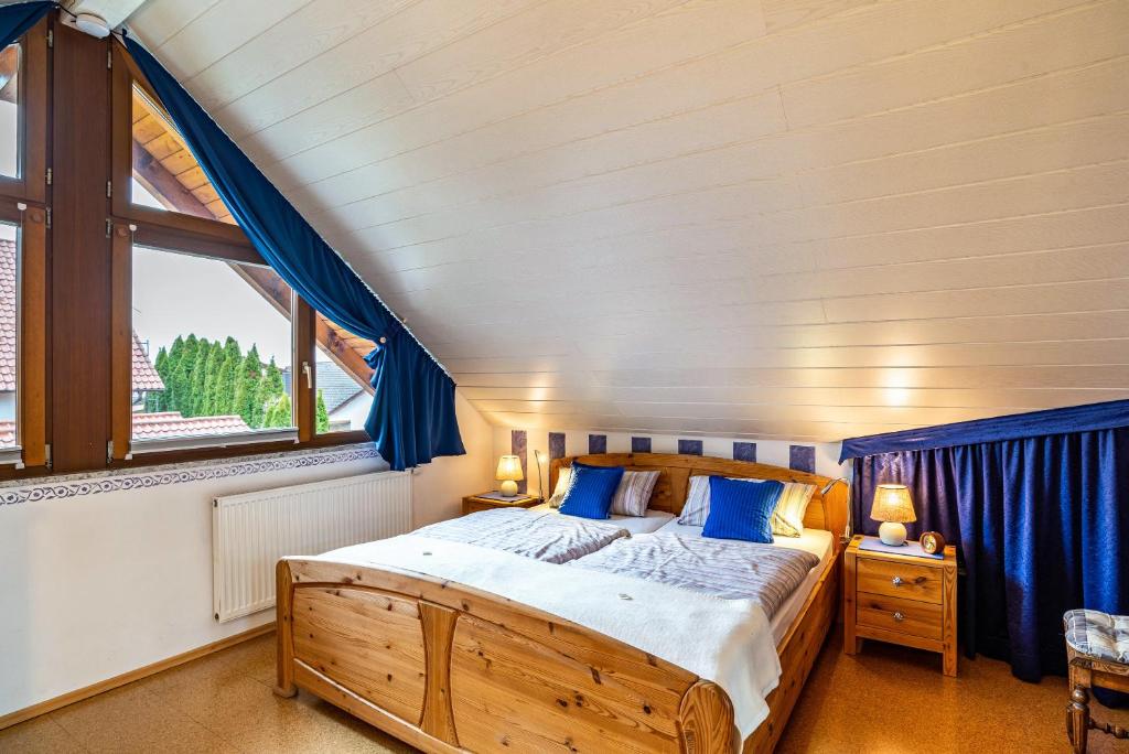 sypialnia z drewnianym łóżkiem z niebieskimi zasłonami w obiekcie Burgblick w mieście Lauf