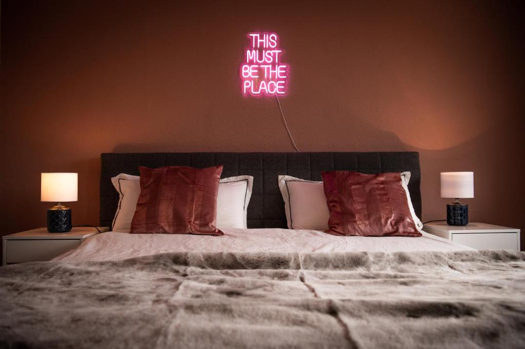 Schlafzimmer mit einem Bett mit Neonschild an der Wand in der Unterkunft Apartment Strauss #DREI 3 Zi BS-Nordstadt in Braunschweig
