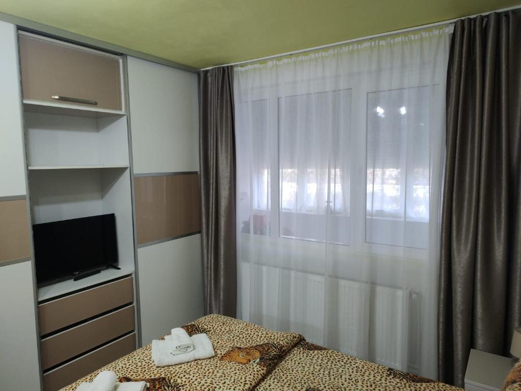a bedroom with a bed with towels and a window at Family Rooms Hunedoara in Hunedoara