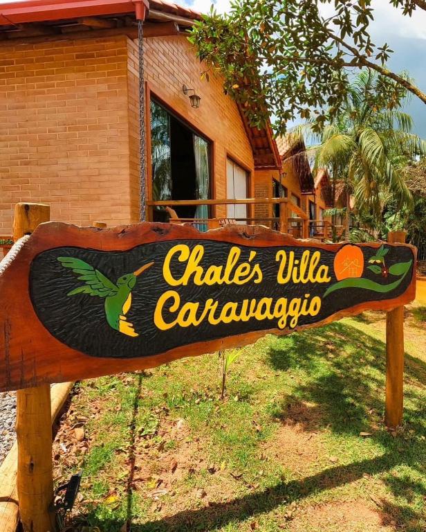 a wooden sign in front of a house at Chalés Villa Caravaggio in Santa Teresa