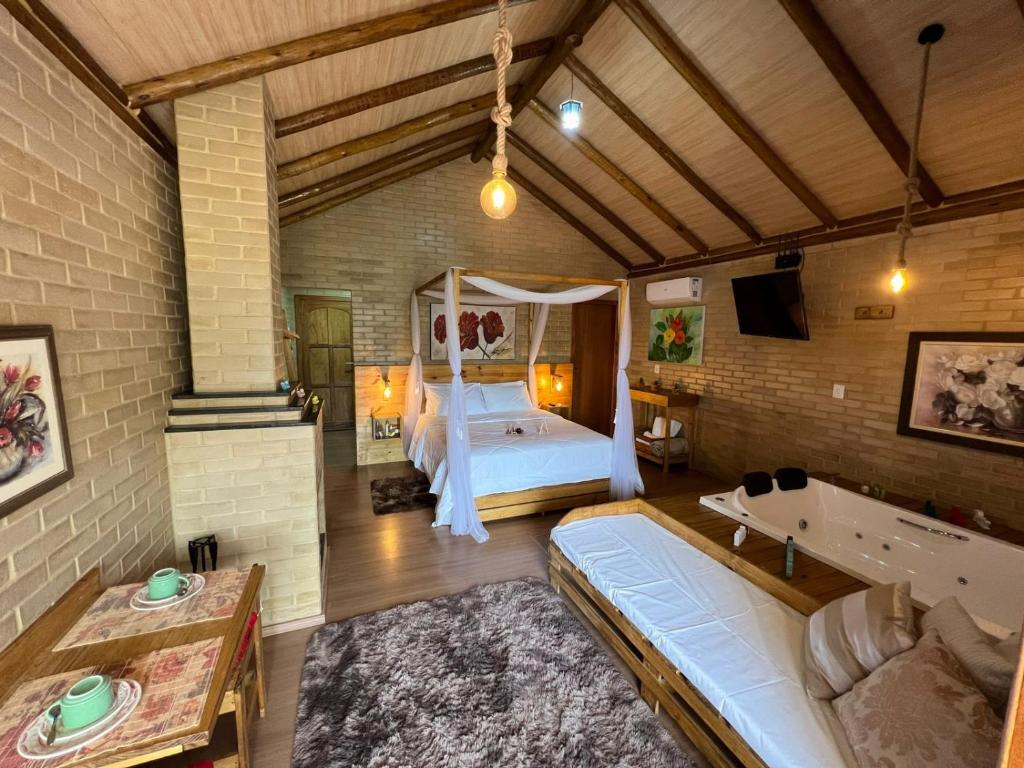 sypialnia z łóżkiem w ceglanej ścianie w obiekcie Chalés Villa Caravaggio w mieście Santa Teresa