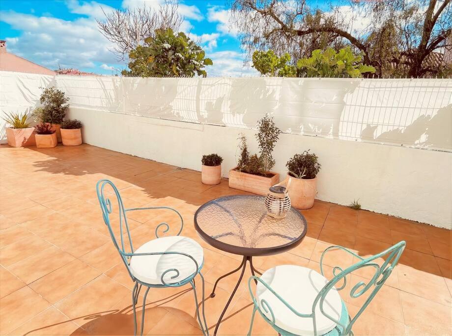 um pátio com uma mesa, cadeiras e uma cerca em Cozy apartment with private courtyard em Barcarena