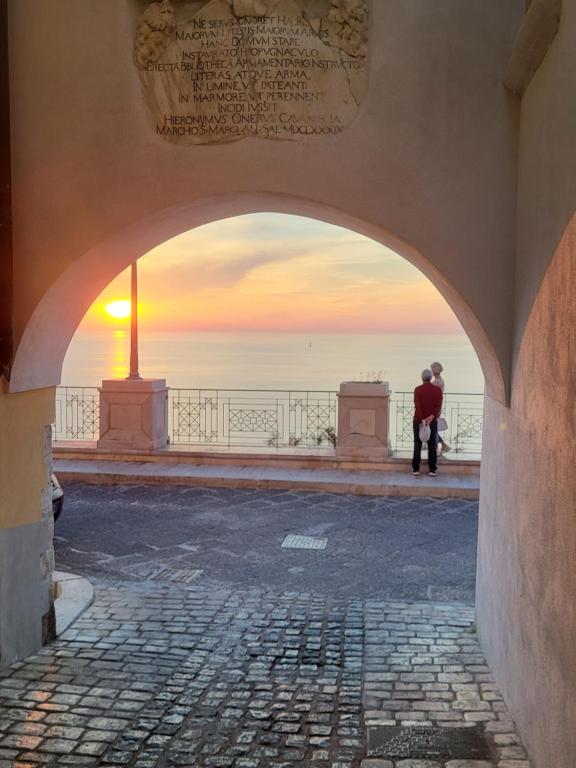 an archway with a man looking out at the ocean at Nonna Libera Vista Mare in Rodi Garganico