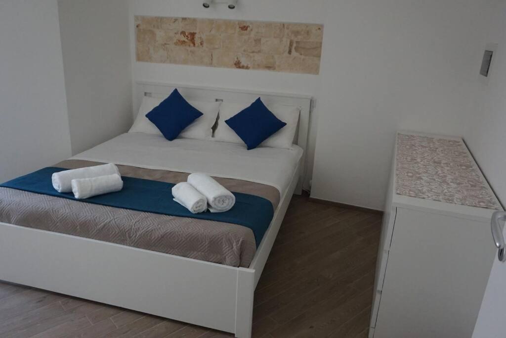 Un dormitorio con una cama con almohadas azules y blancas. en Il Sogno di SaZa, en Castellana Grotte