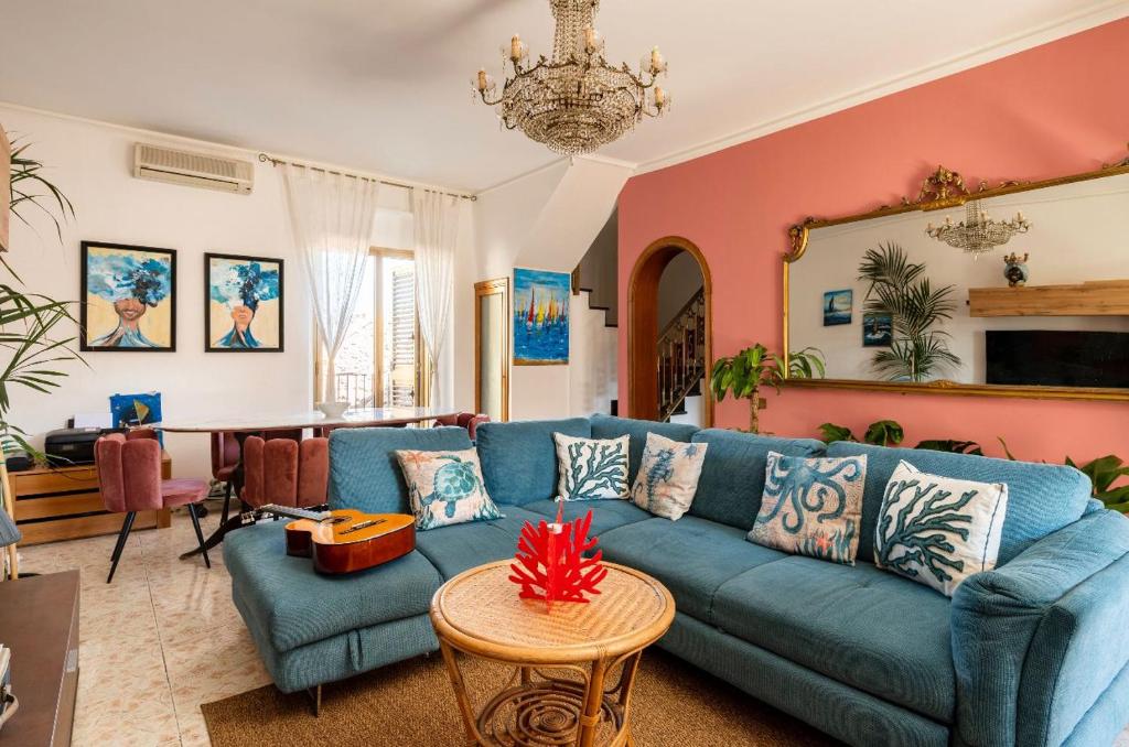 uma sala de estar com um sofá azul e uma mesa em Follow The Sun Catania - Rooftop Terrace em Catânia