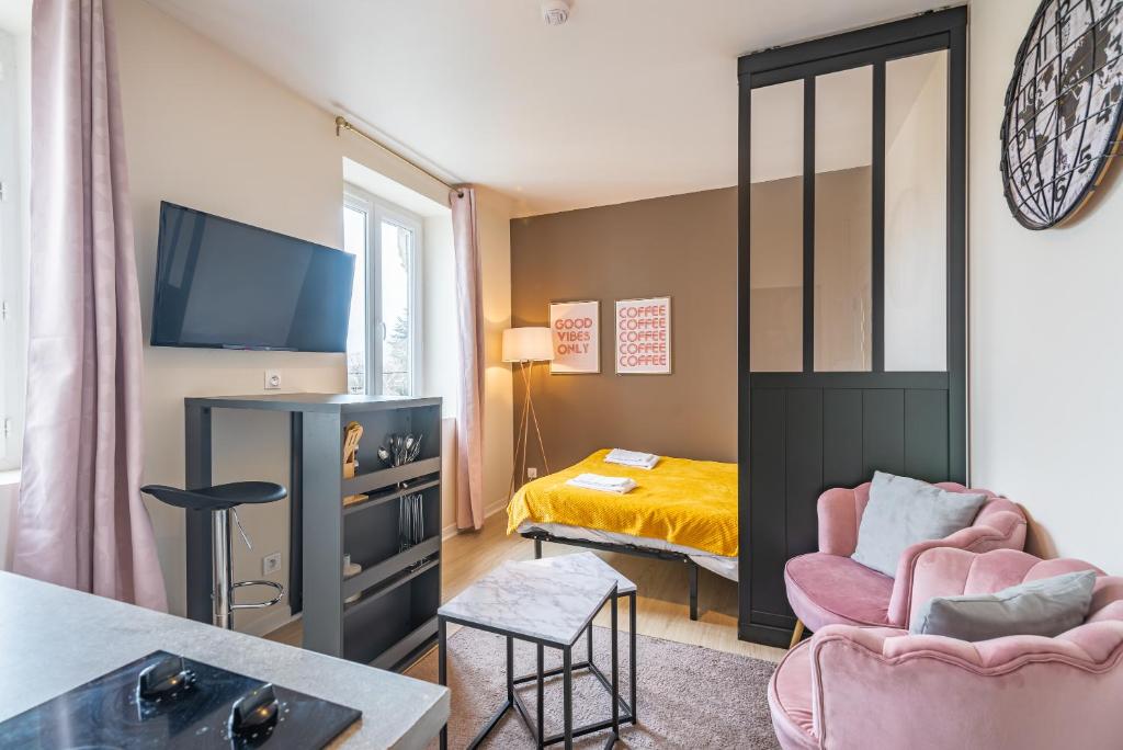 een kleine woonkamer met een bed en een televisie bij Bistrot 10 in Nazelles