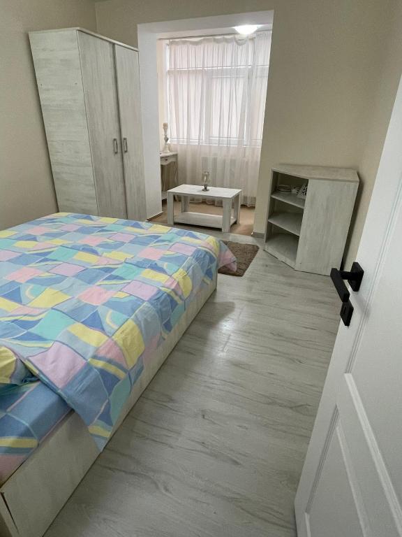 a bedroom with a bed with a colorful comforter at Apartament 2 camere ultracentral in Giurgiu