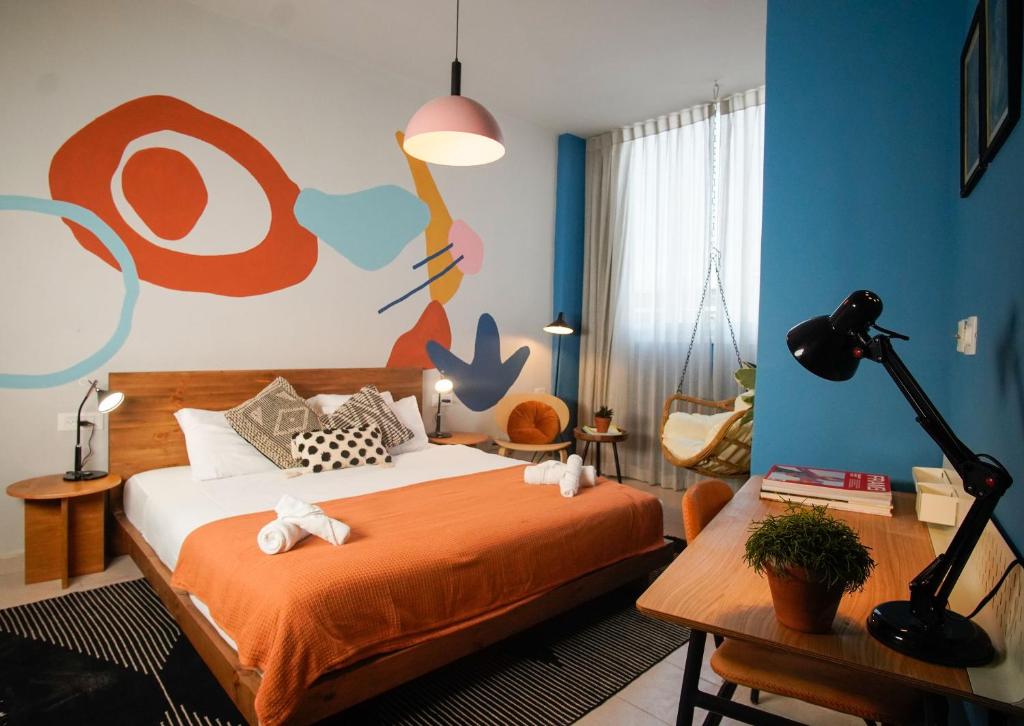 a bedroom with a bed with a painting on the wall at Selina Frishman Tel Aviv in Tel Aviv