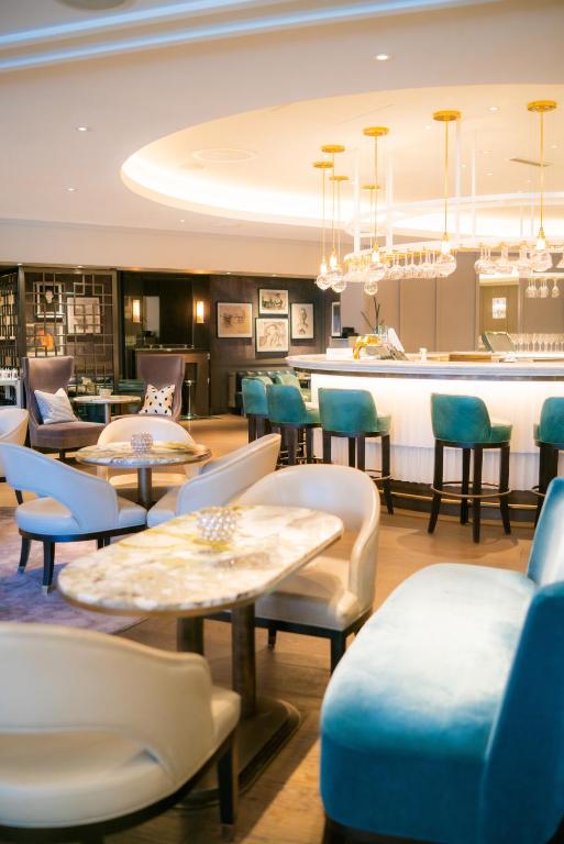 a restaurant with tables and chairs and a bar at Hotel Continental in Oslo