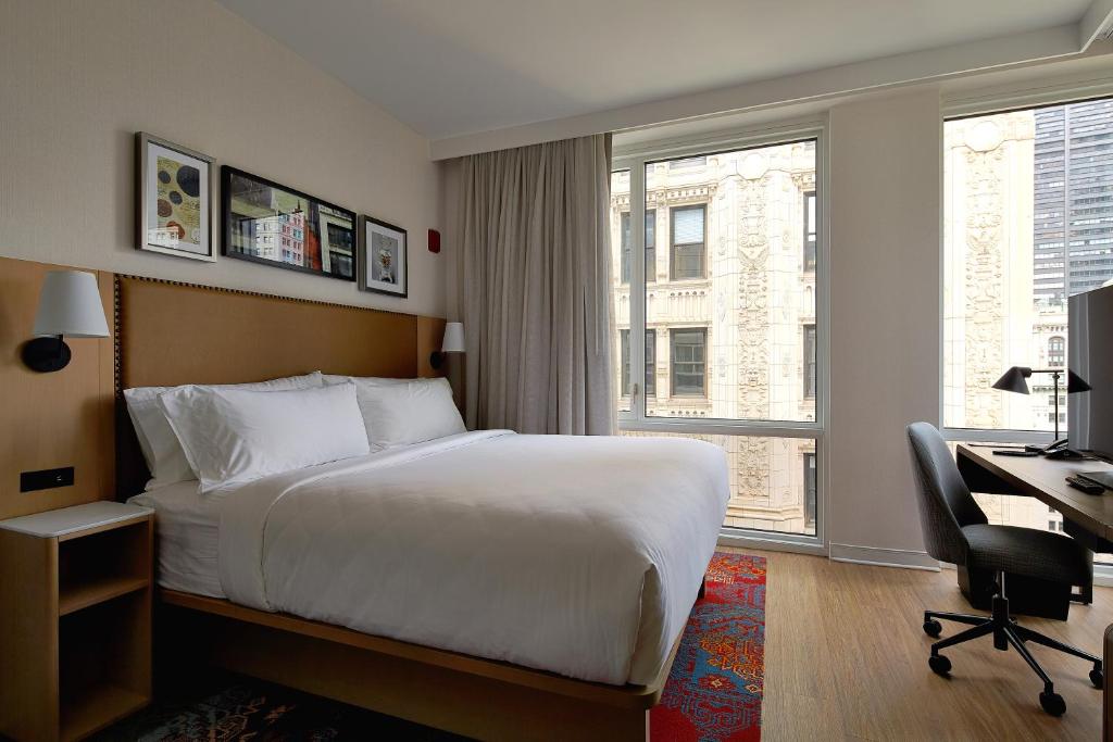 a hotel room with a bed and a desk and a window at Hotel Indigo NYC Financial District, an IHG Hotel in New York