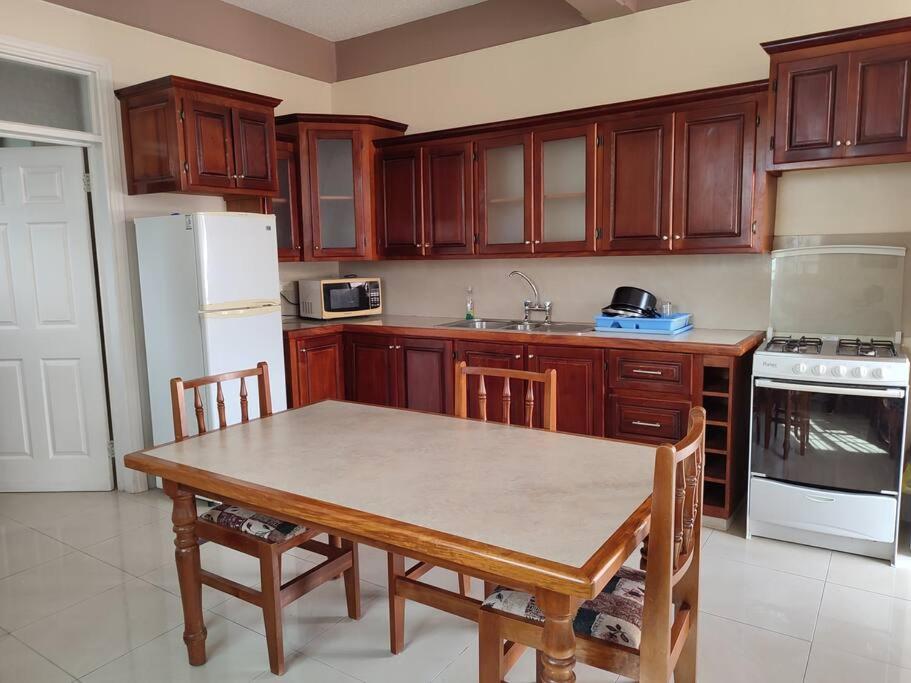 eine Küche mit einem Tisch und einem weißen Kühlschrank in der Unterkunft Iso’s Vacation Rental Apartment #7 in Portsmouth