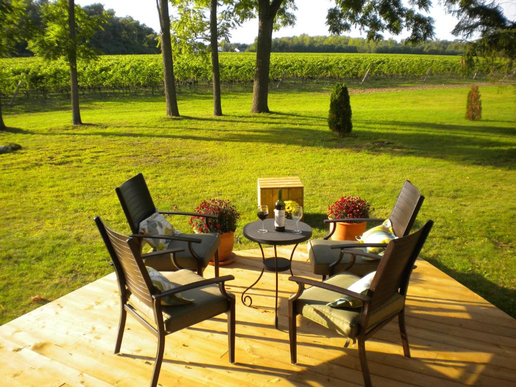 une terrasse avec une table, des chaises et un champ dans l'établissement Vineyard Villa, à Niagara on the Lake
