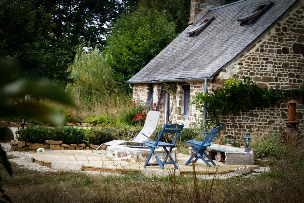 Dos sillas azules sentadas en un patio frente a una casa en Idyllic Rural peaceful Cottage, en Gorron