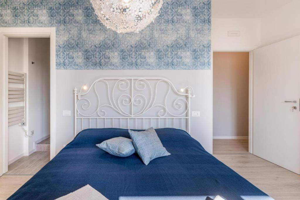 - une chambre avec un lit bleu et un lustre dans l'établissement Family & Friends Rooms, à Padoue
