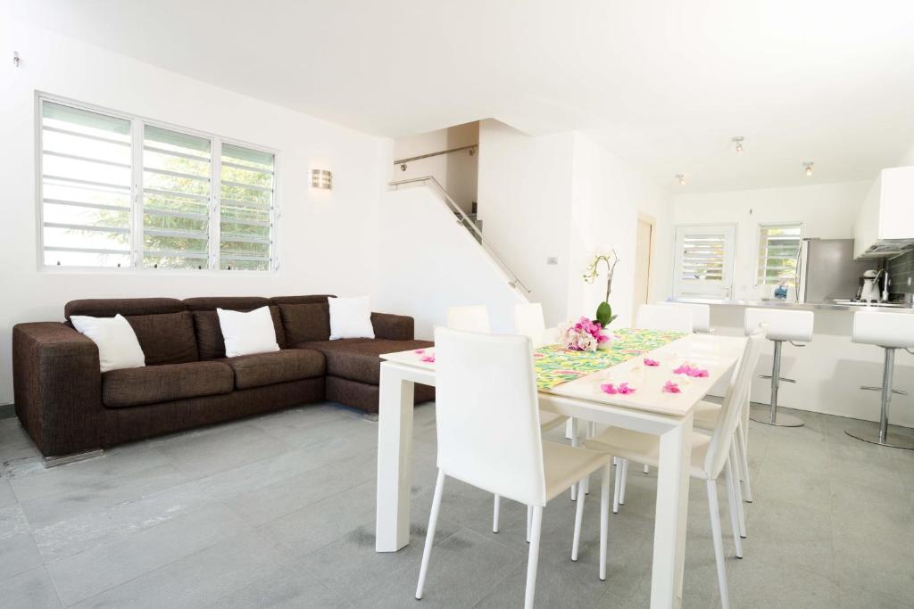 a living room with a white table and a couch at Antigua chiama Italia villas in Jolly Harbour