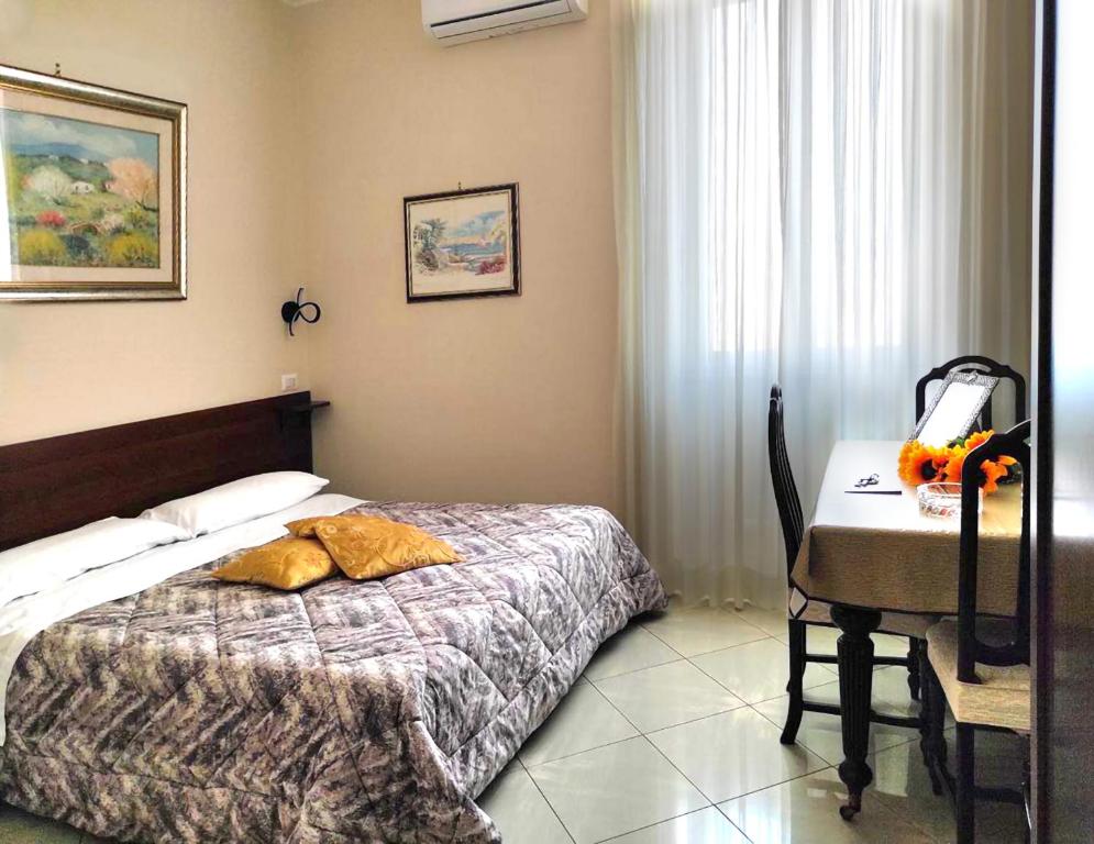 1 dormitorio con 1 cama y escritorio con teléfono en Mara's House, en Roma