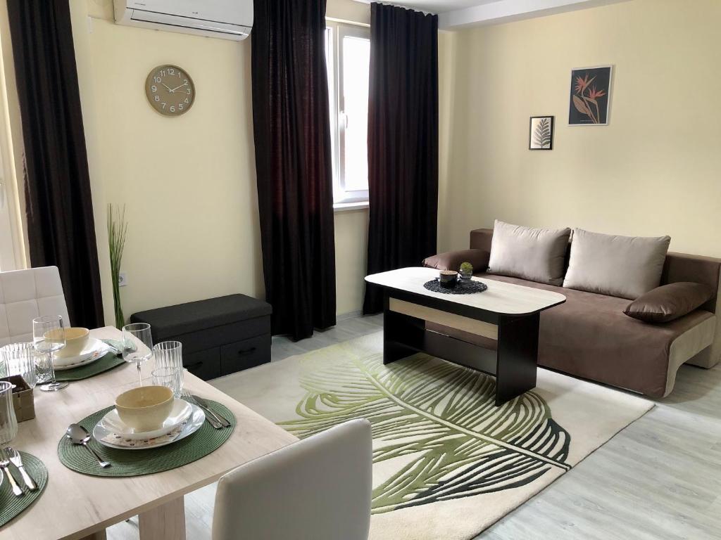 ein Wohnzimmer mit einem Sofa und einem Tisch in der Unterkunft Superb apartment Free Underground Parking in Pasardschik