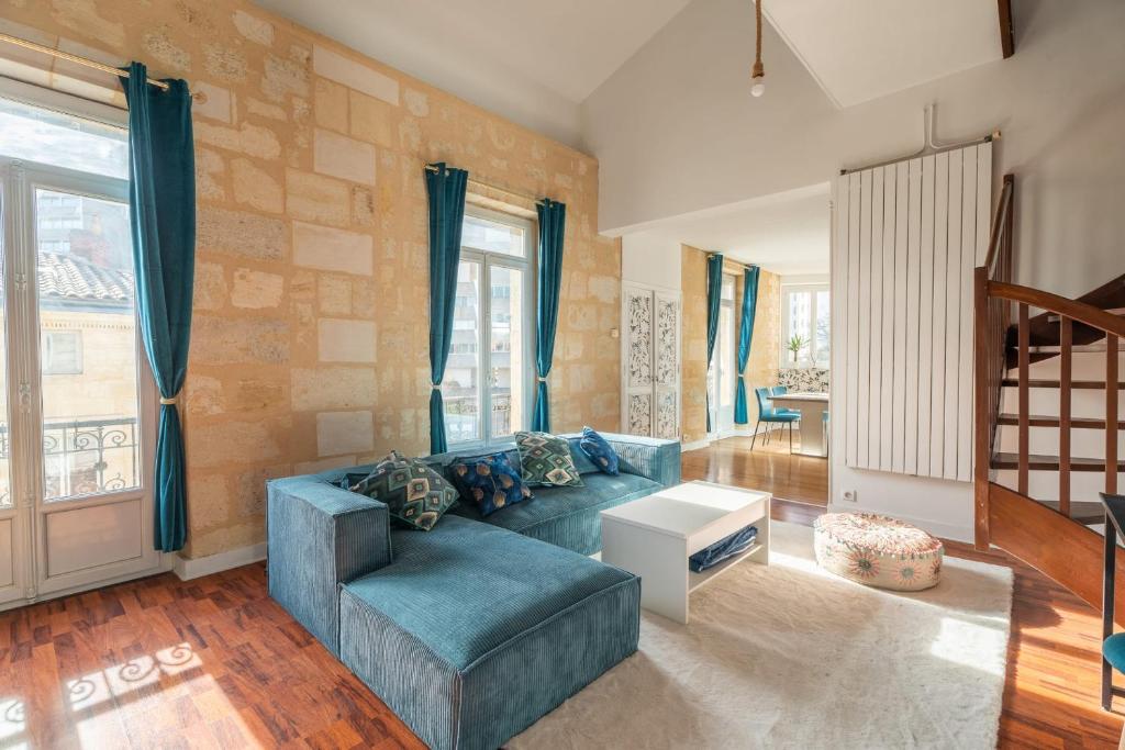 un salon avec un canapé bleu et une table dans l'établissement Large bright duplex in Bordeaux, à Bordeaux