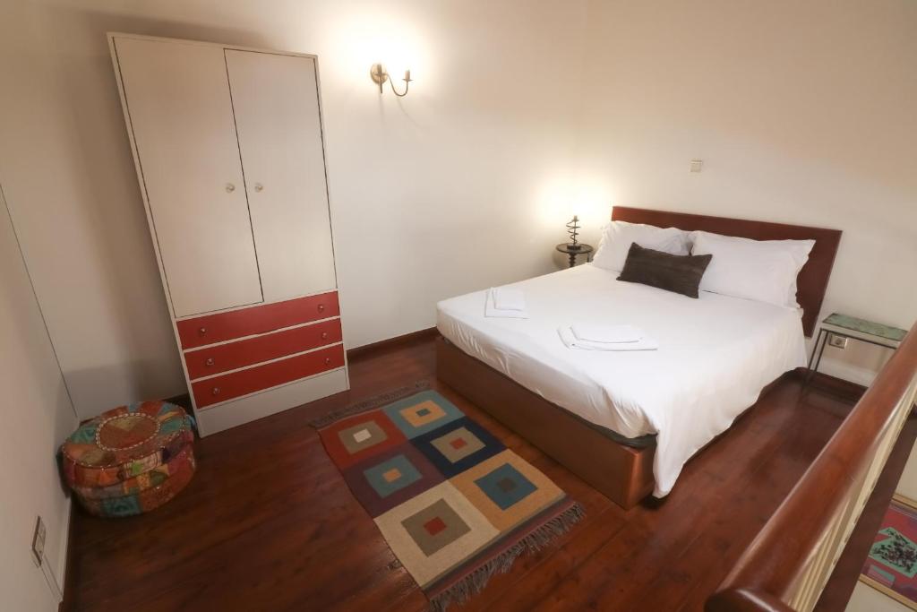 1 dormitorio con 1 cama blanca y armario en CASA 22 en Lagos
