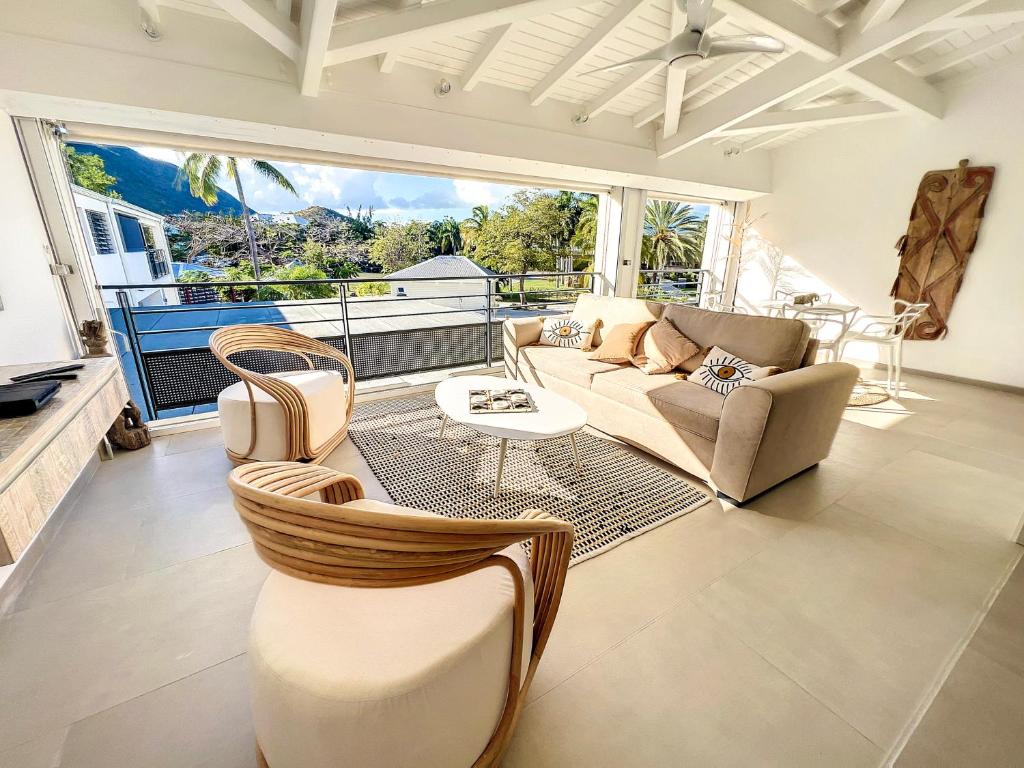 un soggiorno con divano e tavolo di Acacia Tropical, luxurious Duplex, walkable beach ad Anse Marcel