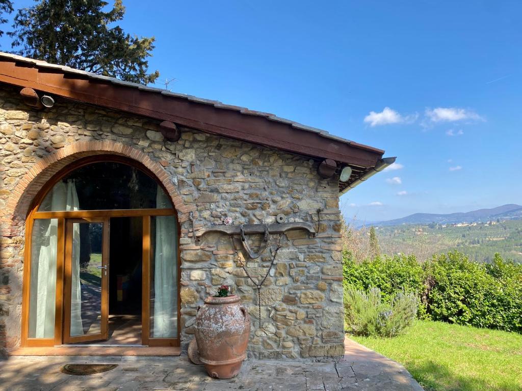 un edificio in pietra con un grande vaso di fronte di Berenice in Chianti a Bagno a Ripoli