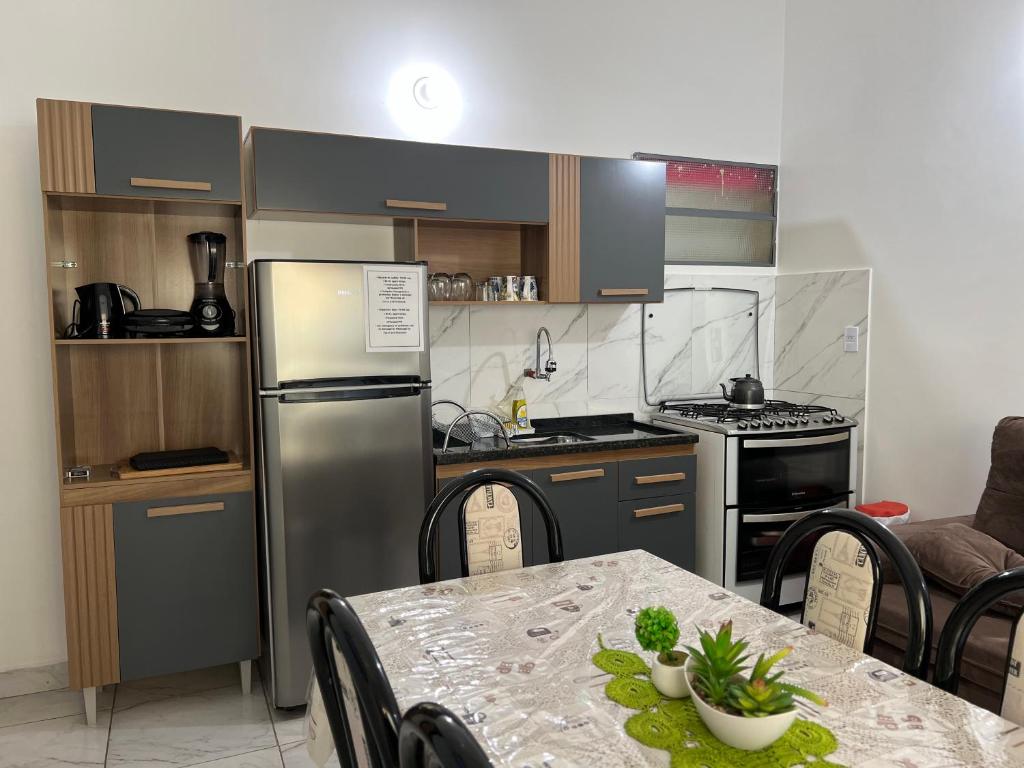 a small kitchen with a table and a refrigerator at Sirius Apart in Puerto Iguazú