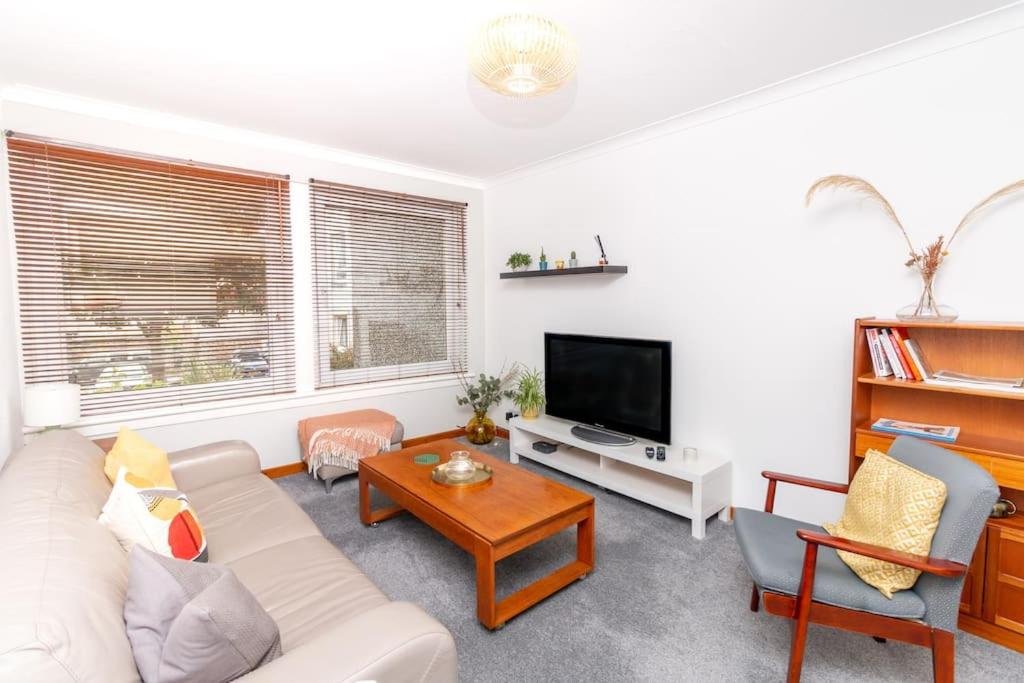 a living room with a white couch and a tv at 'Sunset View' Eclectic & Stylish One Bed Apartment (3 guests) in Fife