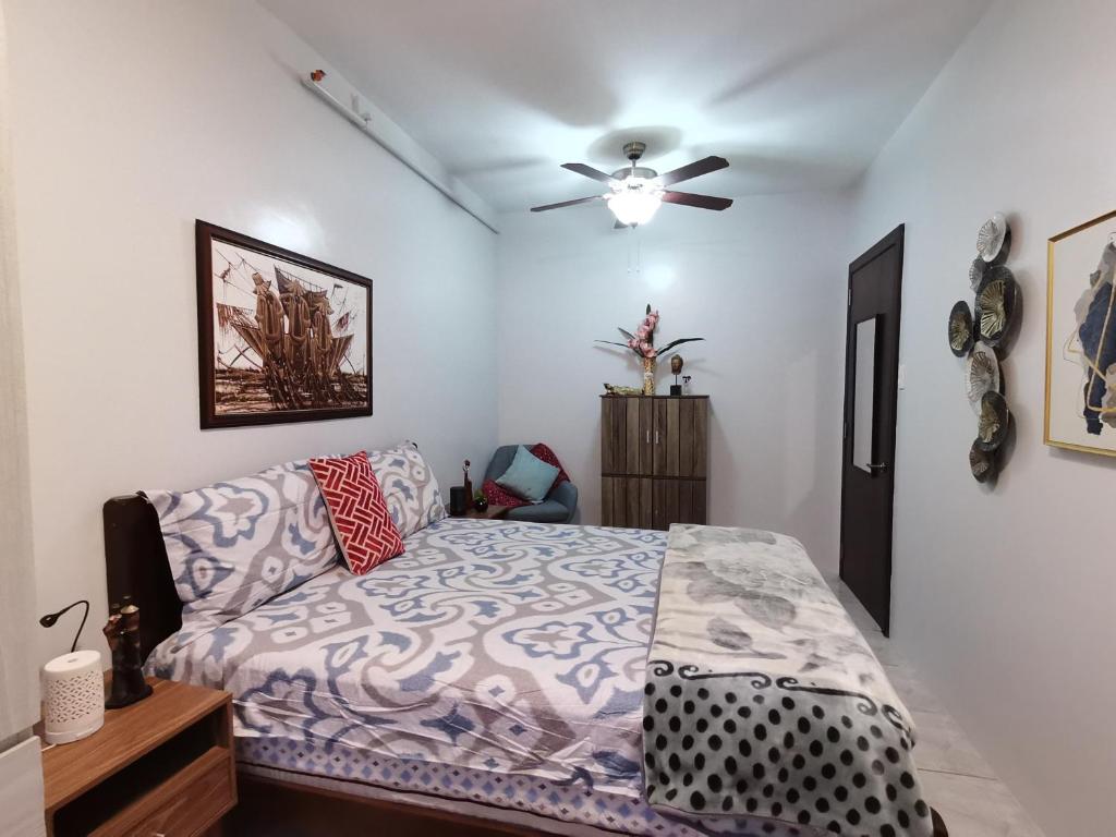 Schlafzimmer mit einem Bett und einem Deckenventilator in der Unterkunft RW 5F 5 Cozy 2BR Goshen Land Towers, in Baguio City