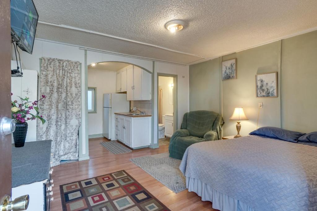 ein Schlafzimmer mit einem Bett und einem Stuhl sowie eine Küche in der Unterkunft Pet-Friendly Loveland Studio Near Boyd Lake! in Loveland