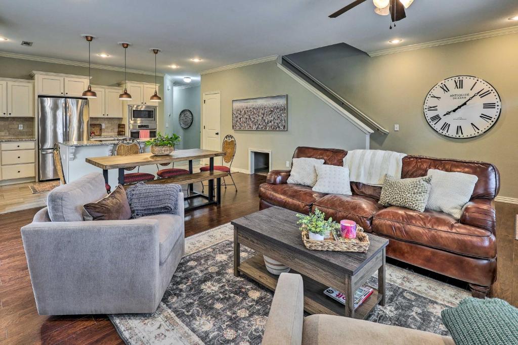 a living room with couches and a clock on the wall at Fayetteville Home Near University of Arkansas! in Fayetteville