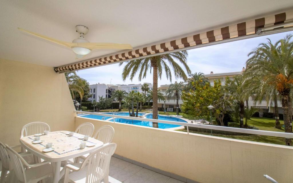 a balcony with a table and chairs and a swimming pool at Las Terrazas - Apartamento en segunda línea Playa Cargador ALBERT VILLAS in Alcossebre