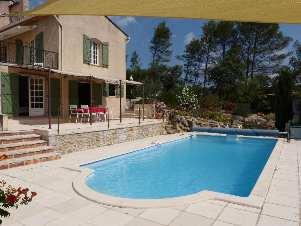 a large blue swimming pool in front of a house at la Rousserolle in Carcès