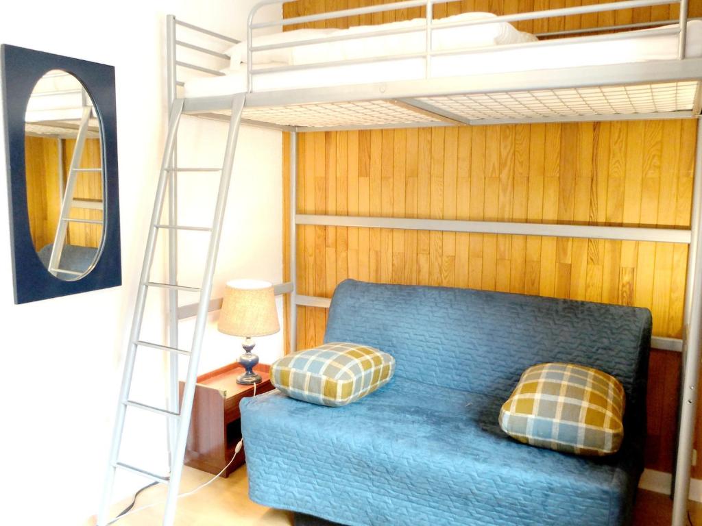 - une chambre avec des lits superposés et un canapé bleu dans l'établissement Studio lumineux proche des pistes avec WIFI - FR-1-502-436, à Tignes