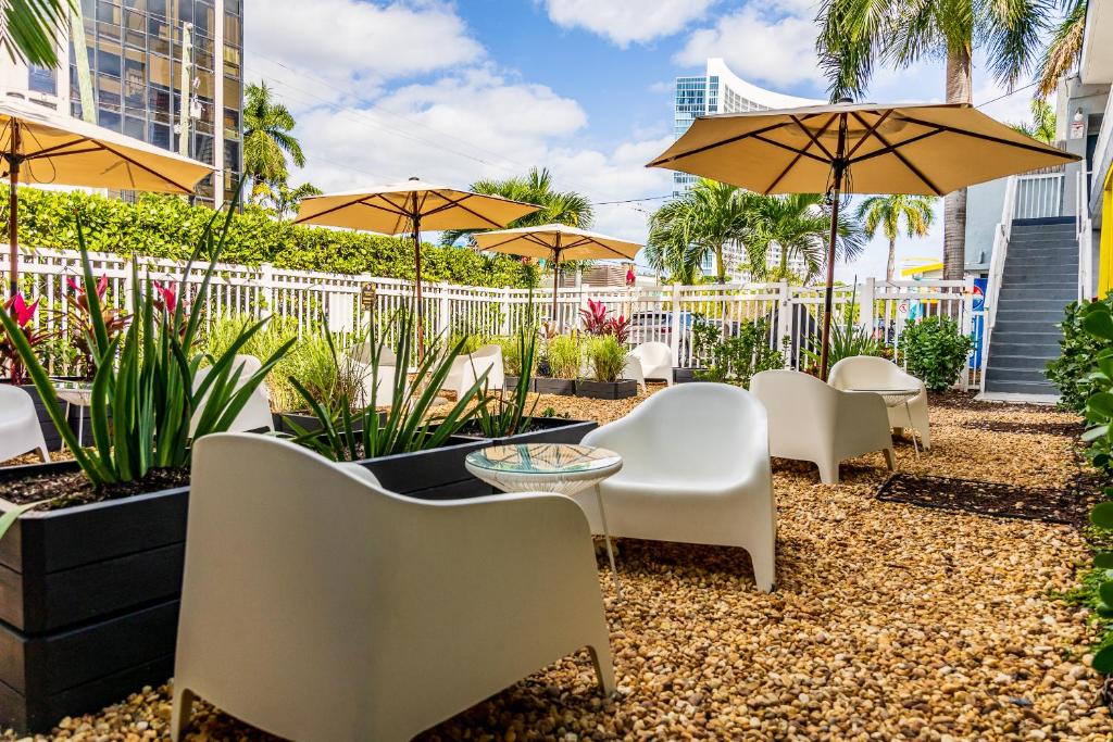 een patio met stoelen, tafels en parasols bij Up Midtown in Miami