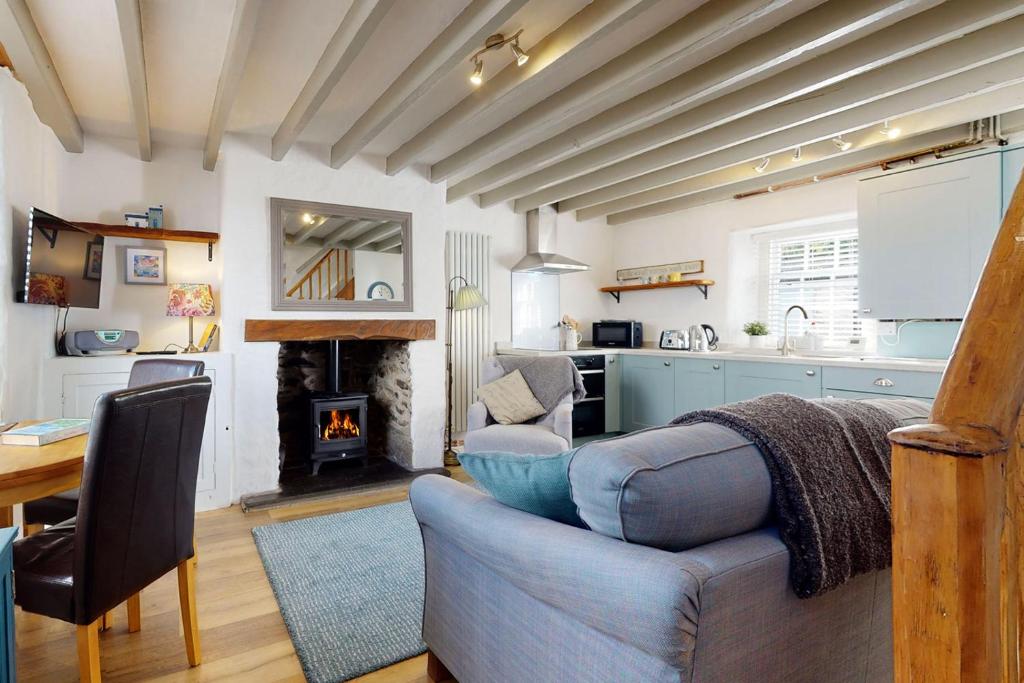 Il dispose d'une cuisine et d'un salon avec un canapé et une cheminée. dans l'établissement Gull Cottage, à Conwy