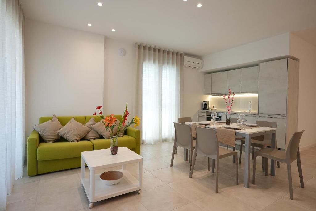 匡迪莫迪卡的住宿－Keys of Sicily Marina di Modica，客厅配有桌子和绿色沙发
