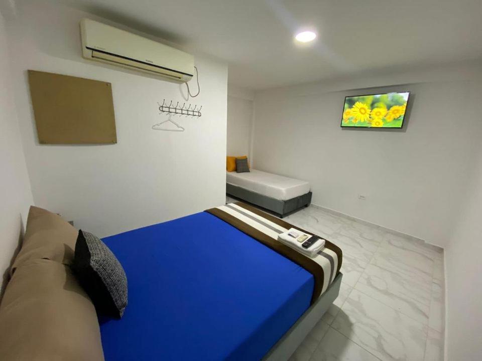 ein Schlafzimmer mit einem blauen Bett in einem Zimmer in der Unterkunft Hotel Aventura Riohacha in Ríohacha