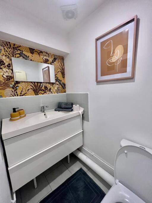 a bathroom with a white sink and a toilet at Suite Lou - Studio _ Résidence Isaelle in Bray-Dunes
