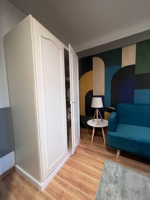 a living room with a blue couch and a table at Suite Lou - Studio _ Résidence Isaelle in Bray-Dunes