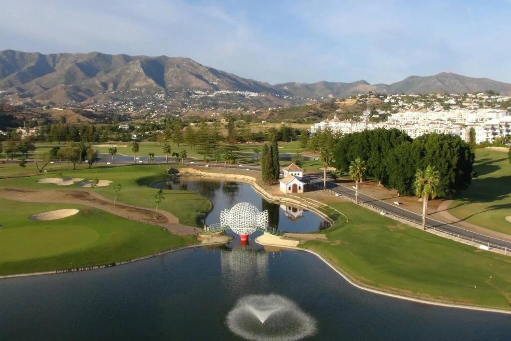 z góry widok na pole golfowe z jeziorem w obiekcie Mijas Golf penthouse w mieście Santa Fe de los Boliches